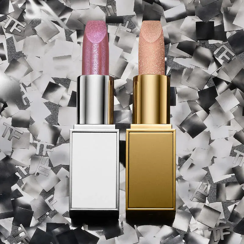 Tom Ford Beauty campaign photograph: a pink and a nude lipstick in white and gold cases on a bed of silver foil squares
